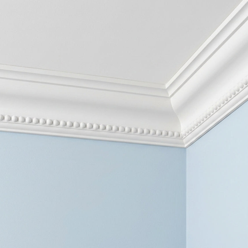 corniche plafond décorative à perles sur un mur bleu pâle